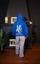 Boxy Fit Hoodie "Signature" Azul Royal con estampando en la espalda de una HC